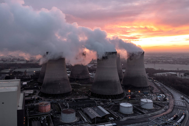 Widok z lotu ptaka na chłodnie elektrowni węglowej zanieczyszczające atmosferę emisją dwutlenku węgla o zachodzie słońca - Zdjęcie, obraz