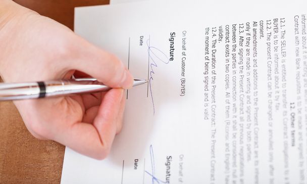 Kupujący podpisuje umowę przez srebrne pióro - Zdjęcie, obraz