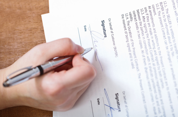 клиент подписывает контракт серебряной ручкой
 - Фото, изображение