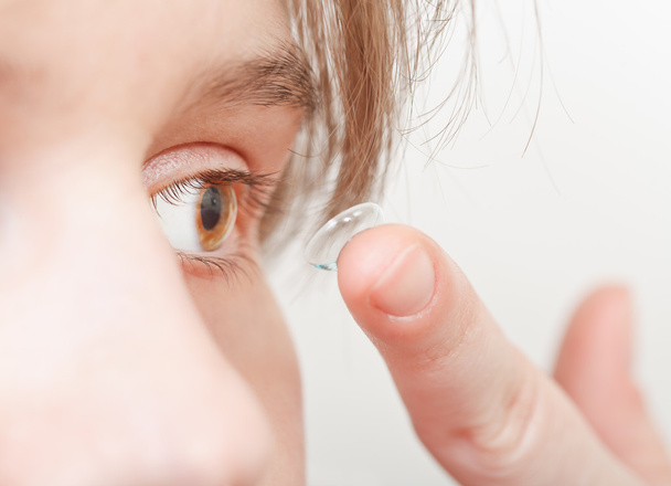 Genç kadın düzeltici lens gözlerinin içine ekler. - Fotoğraf, Görsel