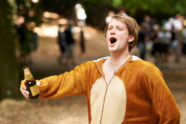 Хесе життя вечірки. молодий чоловік у костюмі мавпи тримає пиво і кричить в збудженні
 - Фото, зображення