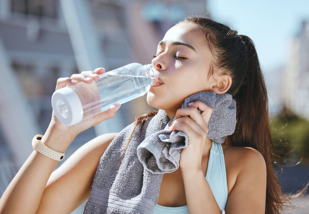 Fitness, woman and water drink for hydration in exercise, workout or training in the city outdoors. Active and athletic female runner drinking refreshing aqua liquid for healthy sports. - Photo, Image