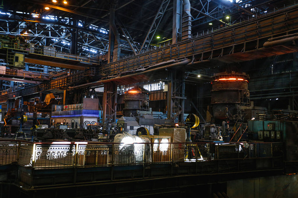 製鉄所の店内からの眺め。大規模な冶金工場で熱い金属のラドル。豚の鉄と鋼を溶かす. - 写真・画像
