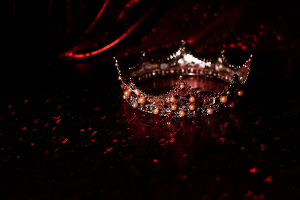 Corona reale con gemme preziose su sfondo di tessuto rosso di lusso - Foto, immagini