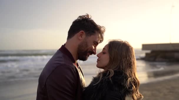 Schönes Paar in der Beziehung umarmt und küsst sich beim ersten Dating - Mädchen und Junge genießen die Freizeitaktivität im Freien am romantischen Strand in der Herbstsaison - Paarbeziehung - Filmmaterial, Video