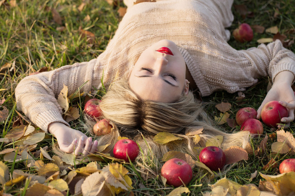 Девушка с яблоком лежит на траве
 - Фото, изображение