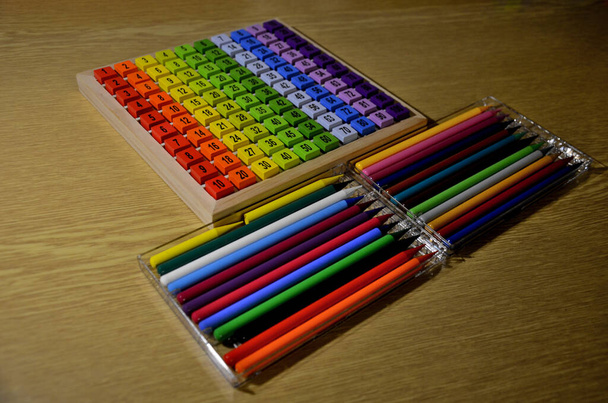 школяр малює кольоровими олівцями та складає набір знань, де є числа з множинами на дерев'яних блоках. множення і ділення можна навчити весело, грайливо в школі
 - Фото, зображення