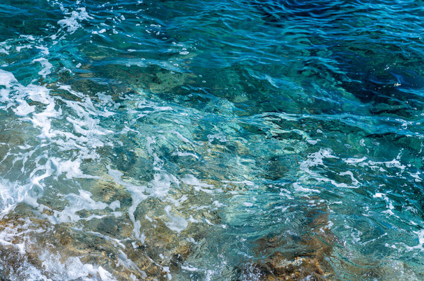 Чисто голубые воды Эгейского моря на острове Тинос, Киклады, Греция - Фото, изображение