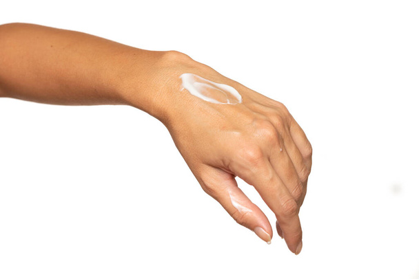 Закрыть обрезанные руки женщины идеальный крем для рук, выделенный на белом фоне студии. Концепция процедур ухода за кожей. Поза с увлажняющим кремом на руке. - Фото, изображение