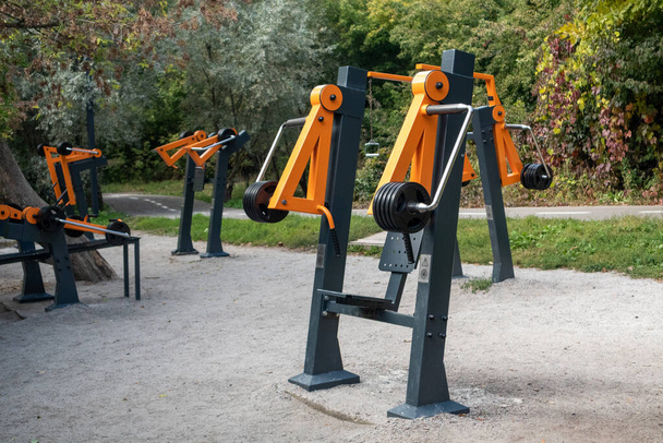 Campo sportivo all'aperto con attrezzature per l'allenamento con i pesi nel parco cittadino. Spazio di allenamento comunale in area ricreativa verde - Foto, immagini