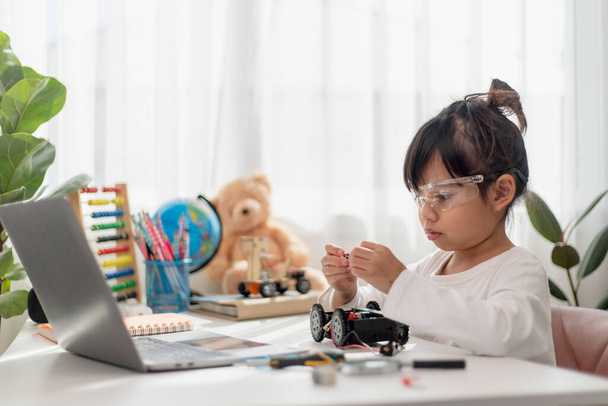Ασία φοιτητές μαθαίνουν στο σπίτι στην κωδικοποίηση ρομπότ αυτοκίνητα και ηλεκτρονικά καλώδια του σκάφους σε STEM, STEAM, μαθηματικά μηχανικής τεχνολογίας κώδικα υπολογιστών στην ρομποτική για τα παιδιά έννοια. - Φωτογραφία, εικόνα