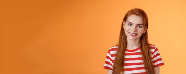Close-up tender cute redhead young woman smiling joyfully, express happiness friendly emotions, look camera silly lovely grin, gaze satisfied, chat delighted, pleasant conversation orange background. - Photo, Image