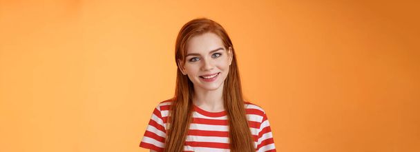 Close-up tender cute redhead young woman smiling joyfully, express happiness friendly emotions, look camera silly lovely grin, gaze satisfied, chat delighted, pleasant conversation orange background. - Photo, Image