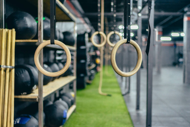 Enfoque selectivo en un conjunto de anillos para hacer ejercicio colgando en un gimnasio - Foto, imagen