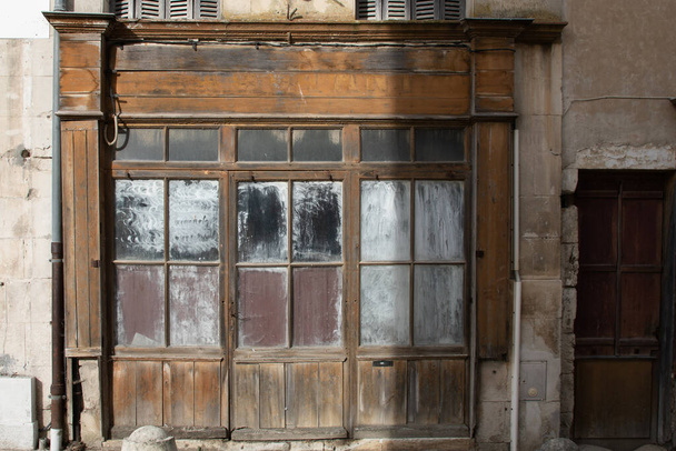 Eski bir ahşap dükkan girişinin terk edilmiş ahşap cephesi. - Fotoğraf, Görsel