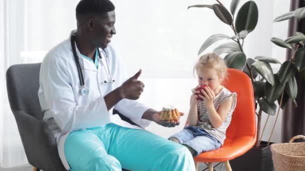 Un médecin afro-américain félicite l'enfant pour une alimentation saine et adéquate - Séquence, vidéo