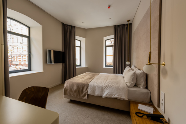 удобная кровать с подушками в современной спальне отеля  - Фото, изображение
