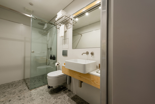 シンクとトイレ付きのモダンな白いバスルームのインテリア   - 写真・画像