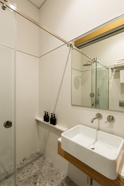 інтер'єр сучасної білої ванної кімнати з туалетом біля білої раковини
  - Фото, зображення