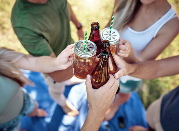 Я выпью за это. Высокий угол съемки молодая группа друзей тост, наслаждаясь несколько напитков на улице под летним солнцем - Фото, изображение
