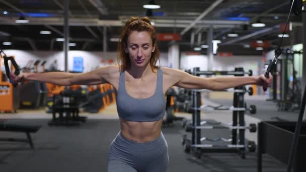 A modern, advanced woman performs sports exercises in the gym to maintain a beautiful body shape and health. Sports training and healthy lifestyle. Sport lifestyle concept. High quality 4k footage - Footage, Video