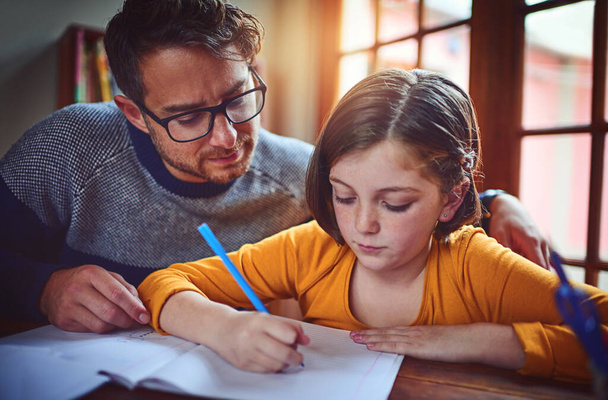 Забезпечення того, що вона завжди любить вчитися. батько допомагає своїй маленькій доньці з домашнім завданням
 - Фото, зображення