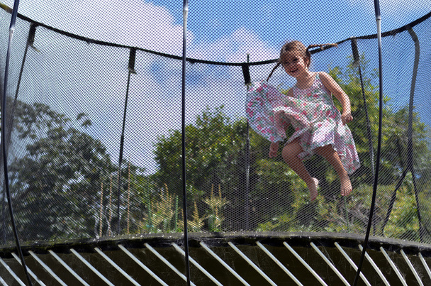 Pieni tyttö hyppää trampolin
 - Valokuva, kuva