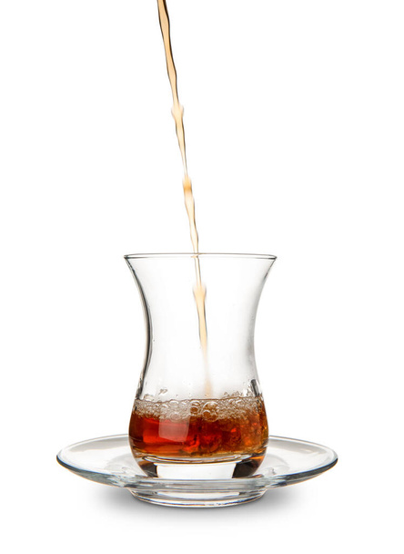 Verter el té turco en un vaso sobre fondo blanco - Foto, imagen