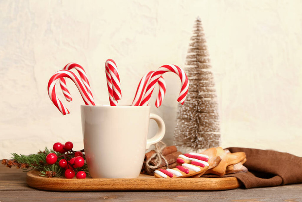 甘いキャンディーの缶、クッキー、木製のテーブルの上のクリスマスの装飾のカップでボード - 写真・画像