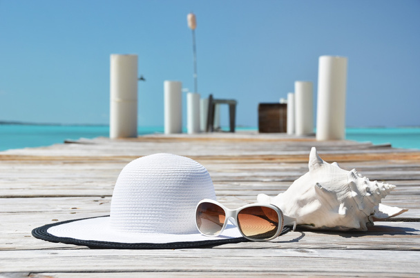 Chapeau et lunettes de soleil sur le quai en bois. Exuma, Bahamas
  - Photo, image