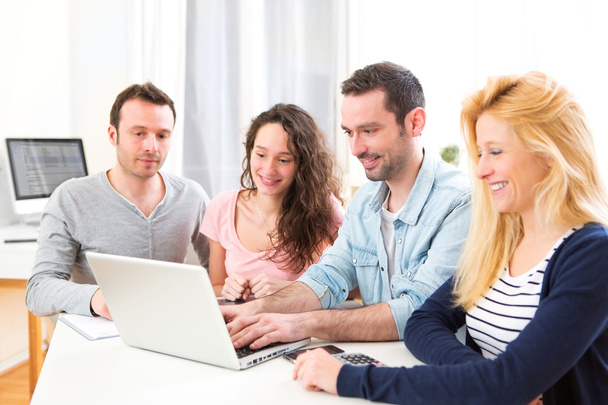 Group of 4 young attractive people working on a laptop - Foto, imagen