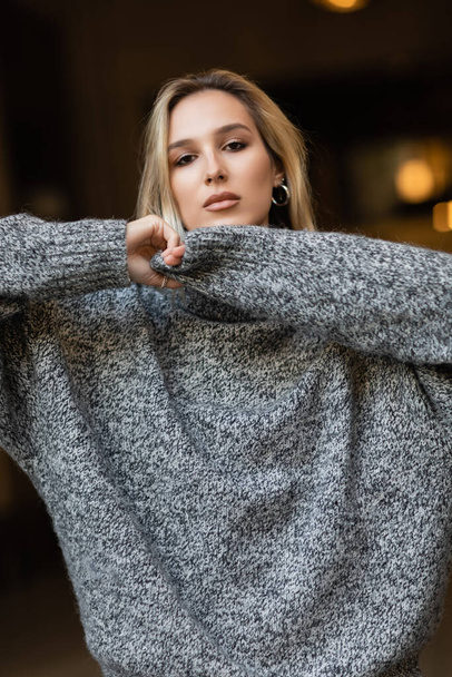 portrait of young blonde woman in grey sweater looking at camera in New York  - Photo, Image