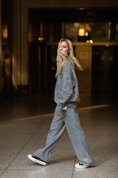full length of young and stylish woman in grey outfit walking on street of New York  - Φωτογραφία, εικόνα
