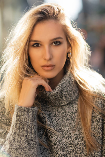 retrato de bela jovem mulher em suéter olhando para a câmera na cidade de Nova York  - Foto, Imagem