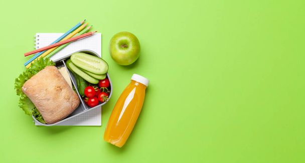 Lunch box with sandwich, vegetables and juice. School or office meal and supplies. Flat lay with copy space - Photo, Image
