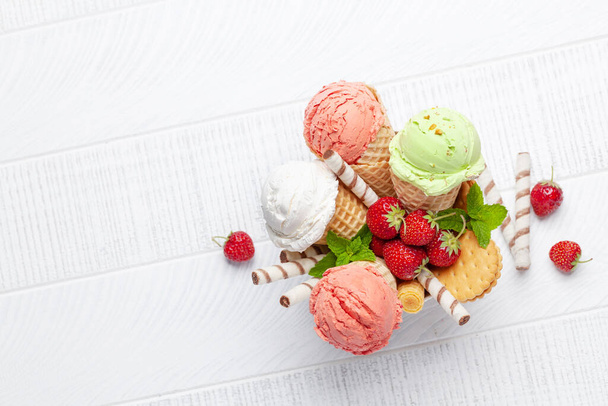 Waffle külahında çeşitli dondurmalar. Çilek, fıstık ve vanilyalı dondurma. Kopyalama alanı olan düz - Fotoğraf, Görsel
