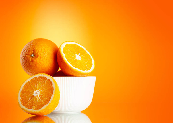 Frische orangefarbene Früchte auf orangefarbenem Hintergrund mit Kopierfläche - Foto, Bild