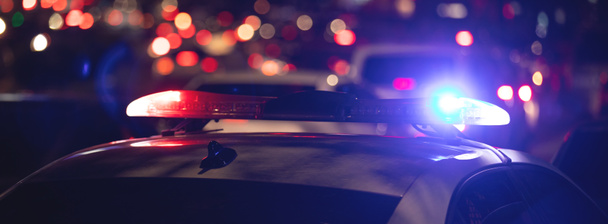 Червоне і синє світло блимає. Поліцейський автомобіль вночі в місті
 - Фото, зображення