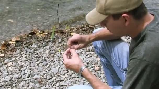 adam nehir kıyısı yakınlarında balıkçılık için hazırlar - Video, Çekim