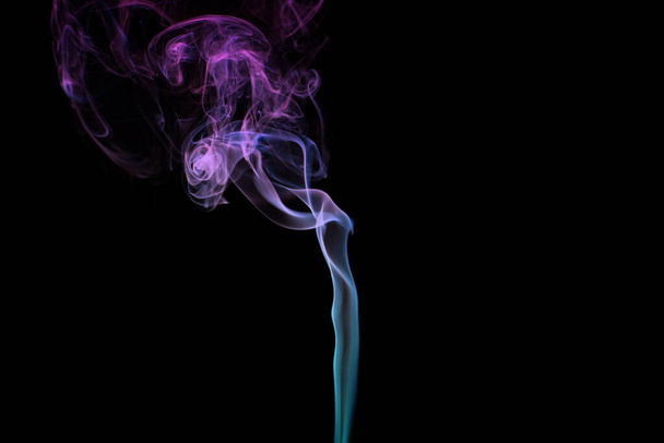 Multicolored smoke for aromatherapy and relaxation on black background, beautiful swirled puffs of smoke. Pink, purple and turquoise gradient colors of dense smoke, decorative multicolour smoke curls - Photo, image