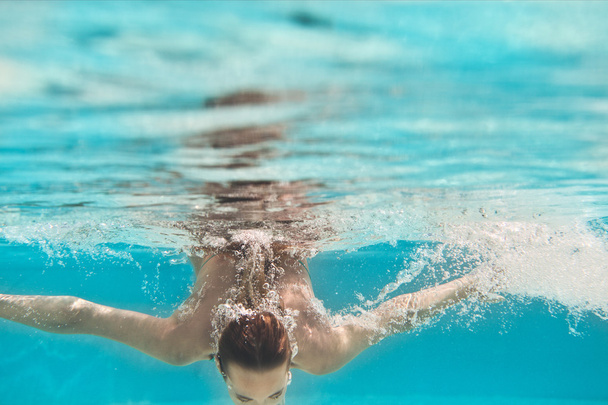 Swimming young woman underwater in pool - Fotoğraf, Görsel
