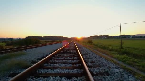 Sonbahar sabahı ışıldayan altın ışıklı demiryolu raylarının üzerine çıkmak. Kırsal demiryolu muhteşem tepe manzarasını geçiyor. Tren istasyonu yakınlarındaki tren yolu ve kavşağı genel görünümü. - Video, Çekim
