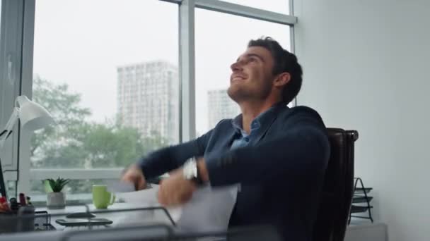 Happy manager throwing papers finishing project. Joyful businessman lean chair relaxing after working day. Smiling entrepreneur celebrating victory enjoy success in office. Smiling winner concept. - Footage, Video