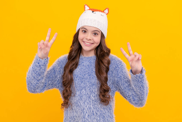 šťastný dospívající dívka nosit pletený klobouk na žlutém pozadí, zima. - Fotografie, Obrázek