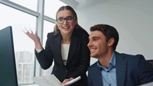 幸せな実業家が同僚と話してる。オフィスでコンピュータマーケティングデータを分析する2人の笑顔のパートナー。楽しい従業員が職場で計画プロジェクトについて話し合います。チーム協力の考え方. - 映像、動画