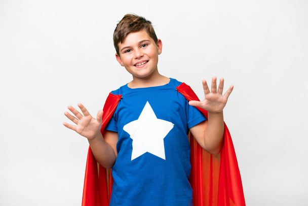 Super hrdina běloch dítě přes izolované bílé pozadí počítání deset s prsty - Fotografie, Obrázek