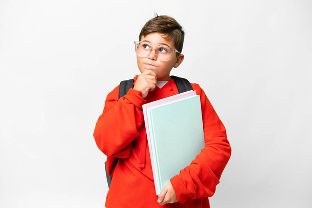 Little caucasian student kid over isolated background having doubts and thinking - Foto, Bild