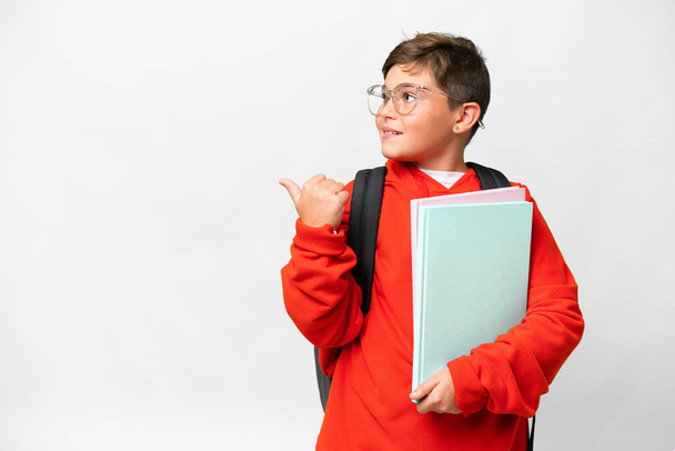 Little caucasian student kid over isolated background pointing to the side to present a product - 写真・画像