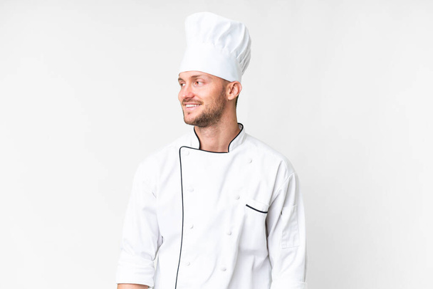 Young caucasian chef over isolated white background looking side - Photo, Image