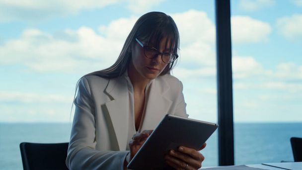 Closeup businesswoman touching tablet at panorama window. Business analyst work searching information using digital pad in suit. Focused financial manager ceo surfing web data preparing presentation. - Photo, Image